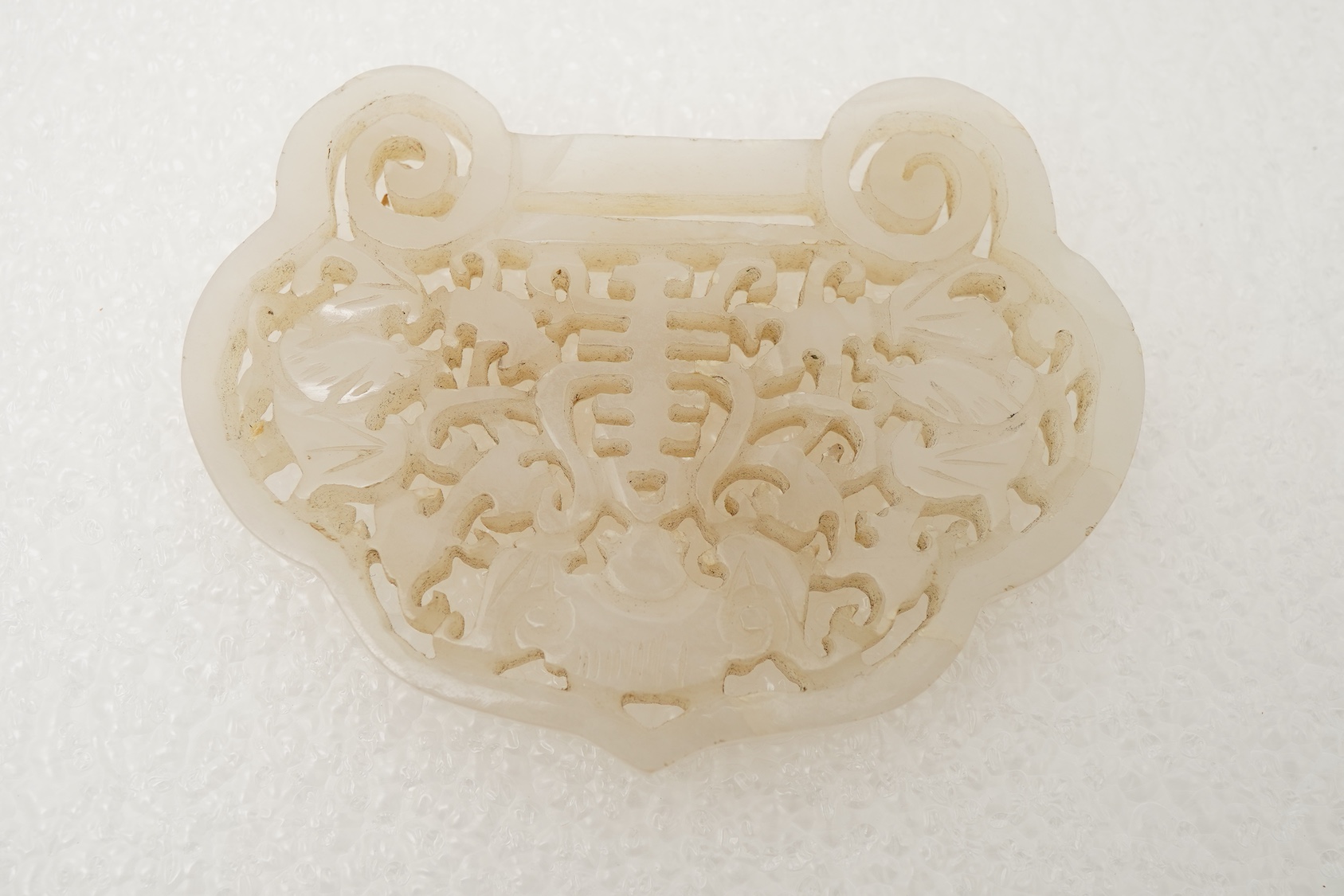 A Chinese jade ‘spirit lock’ plaque, a jadeite bead necklace and a blue quartz bead necklace, 20th century